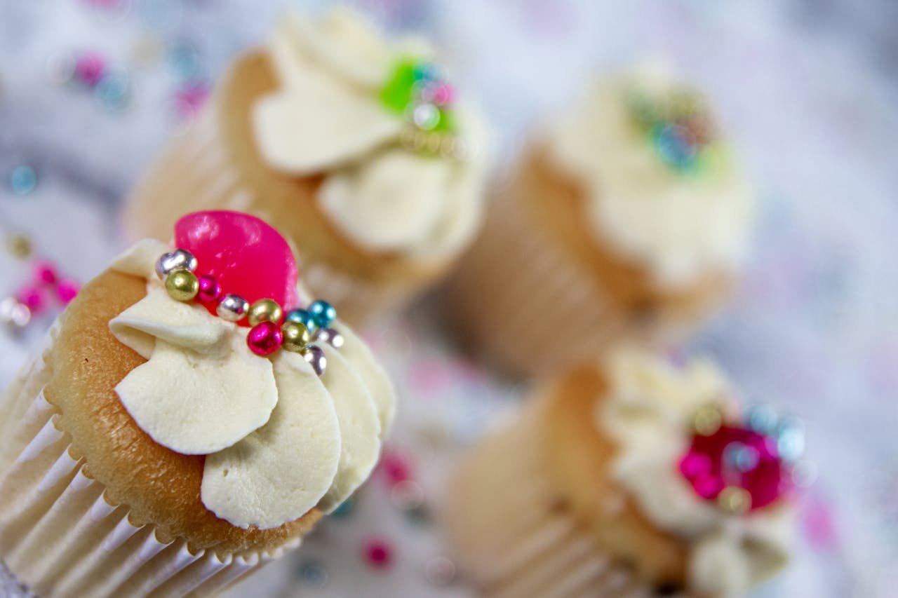 Close-up of decorated cupcakes featuring vibrant beads and creamy icing, perfect for dessert enthusiasts.